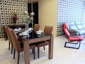 a dining room with a table and chairs and a couch at Luxury 2 BR Suite at The Grove-Masterpiece, Epicentrum in Jakarta
