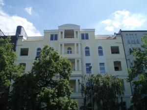 un edificio bianco con alberi di fronte di LV Rooms & Apartments am Lützowplatz a Berlino