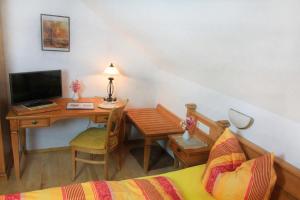 a bedroom with a desk and a bed and a desk with a computer at Gästehaus Ursula in Hornberg +26 photos