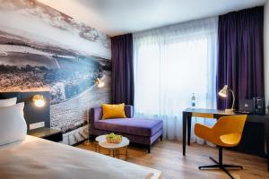 a hotel room with a bed and a desk and a chair at Welcome Hotel Neckarsulm in Neckarsulm