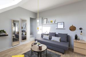 a living room with a blue couch and a table at Azulejo by Cocoonr in Nantes