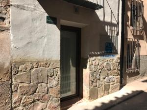 una entrada a un edificio de piedra con ventana en El Encanto de Mora, en Mora de Rubielos