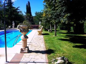 a garden next to a swimming pool with a planter at Chalet cerca de Logroño Villa Mayve in Albelda de Iregua