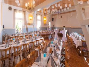 una sala per banchetti con tavoli e sedie bianchi di Hasseröder Hof a Wernigerode