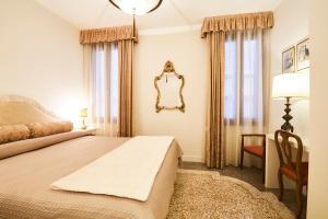 una camera da letto con un letto e uno specchio a parete di Charming Apartment On Grand Canal a Venezia