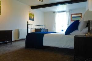 L'Auberdiere في Saint-Jean-des-Essartiers: غرفة نوم بسرير من اللون الازرق والابيض