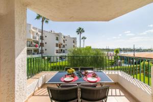 een patio met een tafel en stoelen op een balkon bij Apartamentos CARABELA BEACH Alcudia in Alcudia