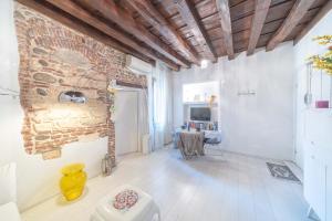 ヴェローナにあるAbbraccio di Giuliettaのレンガの壁とテーブルが備わる広い客室です。