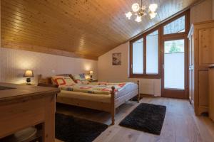 1 dormitorio con 1 cama y algunas ventanas en Hotel Restaurant Silbersand en Riederalp