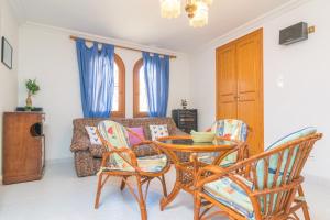 a living room with a table and chairs and a couch at Los Geranios in Can Picafort