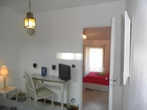 um quarto com uma secretária e um quarto com uma cama em Au Clos de Launay Chambres d’Hôtes em Le Cellier