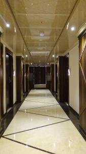 a hallway in a building with a room with a floor at Arna Hotel in Devanhalli