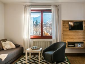 a living room with a couch and a chair and a window at TatryTop Pod Lipkami in Zakopane