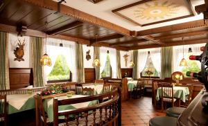 un ristorante con tavoli, sedie e alberi di Natale di Landhotel Bayerwald a Grafling