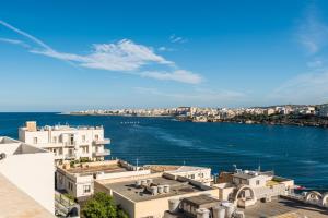 une vue sur une étendue d'eau avec des bâtiments dans l'établissement Bayview 2 bedroom seaview apartment with large terrace with panoramic views - by Getawaysmalta, à San Pawl il-Baħar