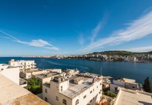 - une vue sur l'eau et les bâtiments dans l'établissement Bayview 2 bedroom seaview apartment with large terrace with panoramic views - by Getawaysmalta, à San Pawl il-Baħar