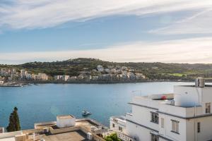 - une vue sur une étendue d'eau depuis un bâtiment dans l'établissement Bayview 2 bedroom seaview apartment with large terrace with panoramic views - by Getawaysmalta, à San Pawl il-Baħar