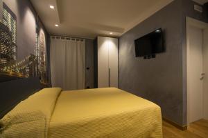 een slaapkamer met een geel bed en een flatscreen-tv bij Le mie città in Pescara
