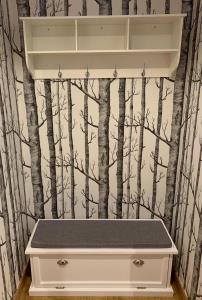 ein Badezimmer mit einer weißen Schublade mit einer Waldtapete in der Unterkunft Apartamentos Maladeta in Benasque