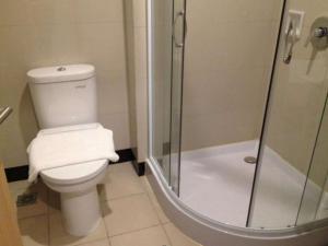 a bathroom with a toilet and a glass shower at Biz Hotel Batam in Nagoya