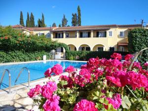 a villa with a swimming pool and pink flowers at Kalypso Gouvia in Gouvia