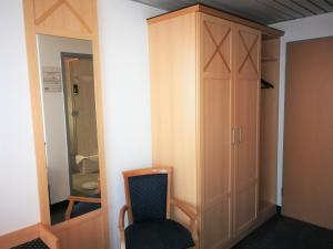 um quarto com uma cadeira e um armário em Hotel NEAR BY em Hanôver