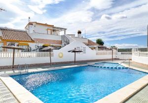 a swimming pool in front of a house at Apartment Eden in Guardamar del Segura