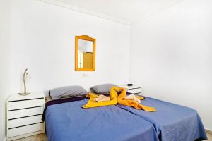 Un dormitorio con una cama con sábanas azules y un espejo. en Apartment Eden, en Guardamar del Segura 41 fotos más