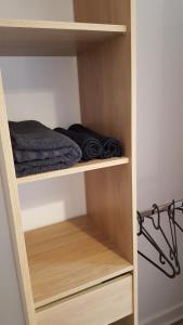 un armadio con scaffali in legno e un letto sopra di Appart Confortable à Tulle - Bien situé - Calme a Tulle