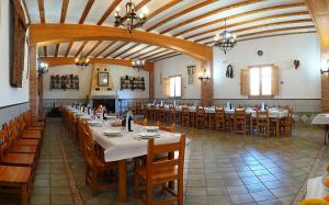 un gran comedor con mesas y sillas en Monasterio El Olivar, en Estercuel