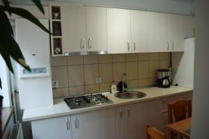 a kitchen with white cabinets and a sink and a stove at Apartament Trei Stejari in Sibiu