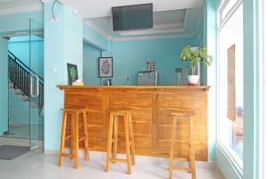 una cucina blu con bancone in legno con sgabelli di RedDoorz near Solo Balapan Station a Solo