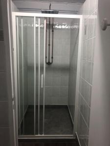 La salle de bains est pourvue d'une douche avec une porte en verre. dans l'établissement Hôtel de la Poste, à Coudes