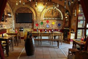 un restaurante con mesas de madera y TV en la pared en Bed & Breakfast Casale Gregoriano and Apartaments, en San Gimignano