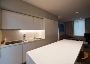 コルトレイクにあるStudio Kの白いキャビネットとシンク付きのキッチン