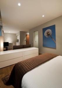 a bedroom with a bed with a dandelion painting on the wall at Studio K in Kortrijk