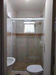 y baño con ducha, aseo y lavamanos. en Chalé da Ana - Ilhabela, en Ilhabela