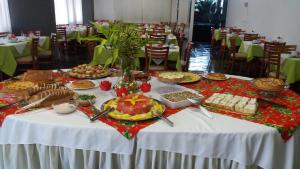 a table full of food on a table in a restaurant at Hotel Sir Ltda in Telêmaco Borba