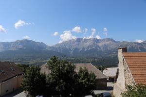a view of the mountains from the roofs of houses at Le Cairn Chambres & Table d'hôtes in Saint-Bonnet-en-Champsaur