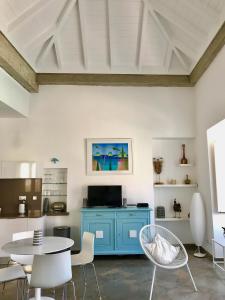 Cette chambre comprend une armoire bleue, une table et des chaises. dans l'établissement Casa Marcelino, à Tavira