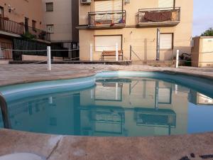 a swimming pool in front of a building at Alcañiz Flats I in Alcañiz