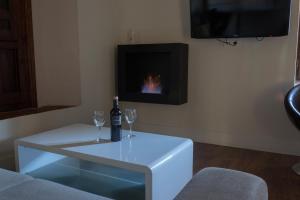 A television and/or entertainment centre at Los Ojos de la Mora Apartamentos Boutique