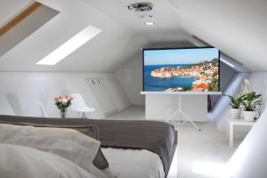 een slaapkamer met een groot scherm op de zolder bij Villa Paulina in Dubrovnik