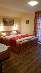 Schlafzimmer mit einem großen Holzbett mit roter Bettwäsche in der Unterkunft Haus Gabriele in Bad Mitterndorf