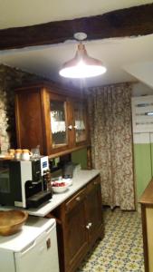 a kitchen with wooden cabinets and a white refrigerator at Casa Apilladeira in Puentedeume +14 photos
