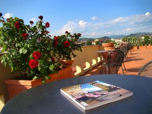 a book on a table on a balcony with roses at Alla Dimora Altea in Florence