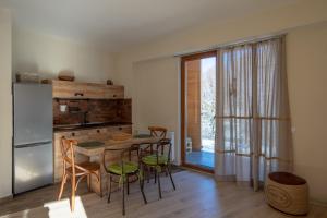 a kitchen with a table and chairs and a refrigerator at Didveli Valley Bakuriani in Bakuriani