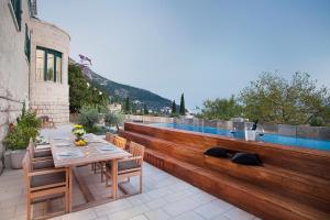 une terrasse avec une table, des chaises et une piscine dans l'établissement Villa Paulina, à Dubrovnik
