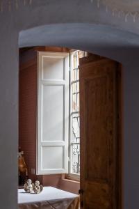 eine offene Tür zu einem Zimmer mit Fenster in der Unterkunft Hotel Alla Corte degli Angeli in Lucca