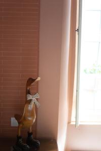 a statue of a duck standing next to a window at Hotel Alla Corte degli Angeli in Lucca